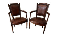 Elegant pair of 20th Century French comfortable worn leather armchairs in the Louis XVI style.