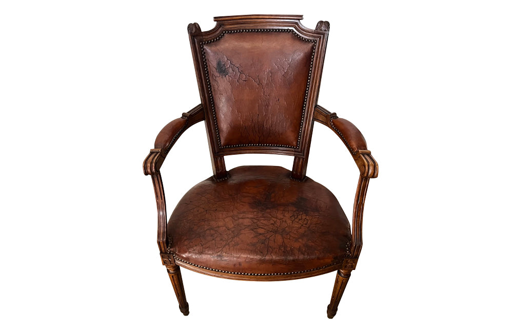 Elegant pair of 20th Century French comfortable worn leather armchairs in the Louis XVI style.