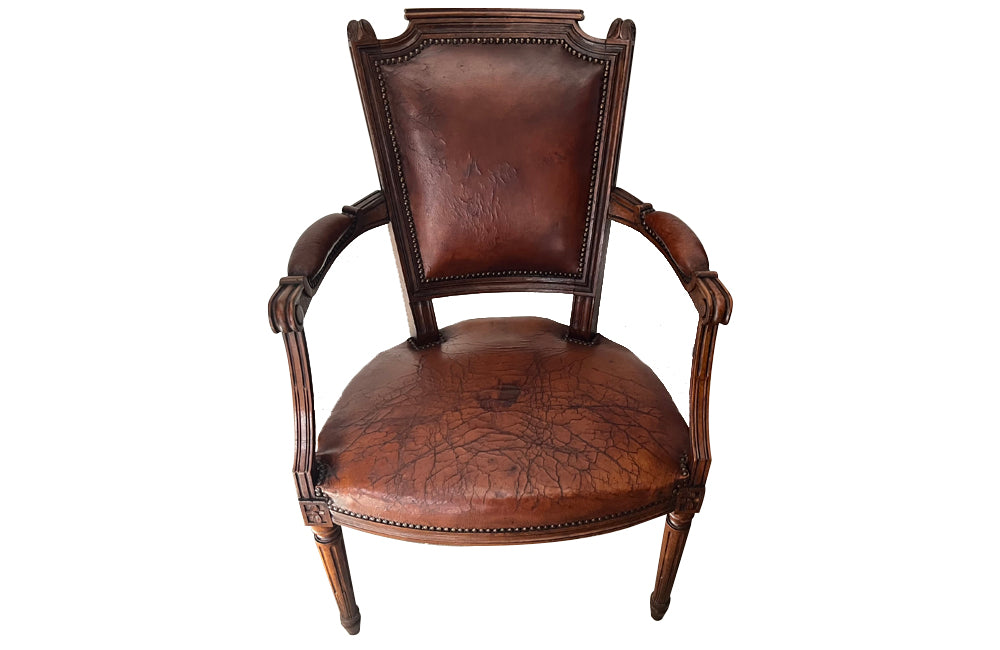 Elegant pair of 20th Century French comfortable worn leather armchairs in the Louis XVI style.