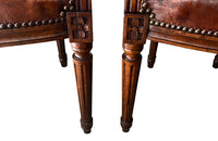 Elegant pair of 20th Century French comfortable worn leather armchairs in the Louis XVI style.