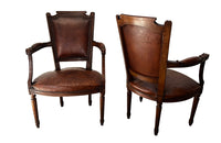 Elegant pair of 20th Century French comfortable worn leather armchairs in the Louis XVI style.