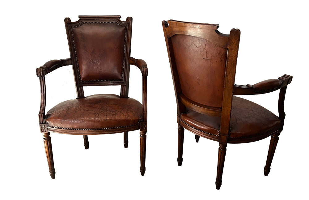 Elegant pair of 20th Century French comfortable worn leather armchairs in the Louis XVI style.