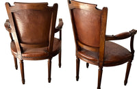 Elegant pair of 20th Century French comfortable worn leather armchairs in the Louis XVI style.