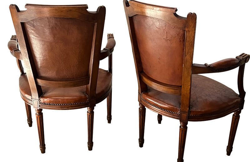 Elegant pair of 20th Century French comfortable worn leather armchairs in the Louis XVI style.