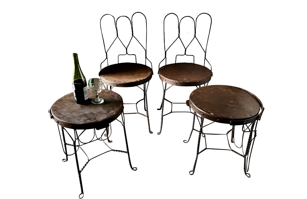 An elegant set of four mid-20th Century French wrought-iron folding chairs of the 'Bouchon de Champagne' type.