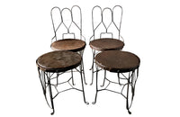 An elegant set of four mid-20th Century French wrought-iron folding chairs of the 'Bouchon de Champagne' type.