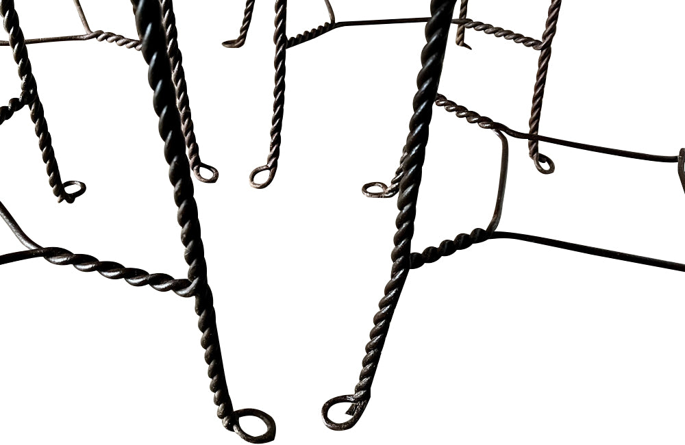 An elegant set of four mid-20th Century French wrought-iron folding chairs of the 'Bouchon de Champagne' type.