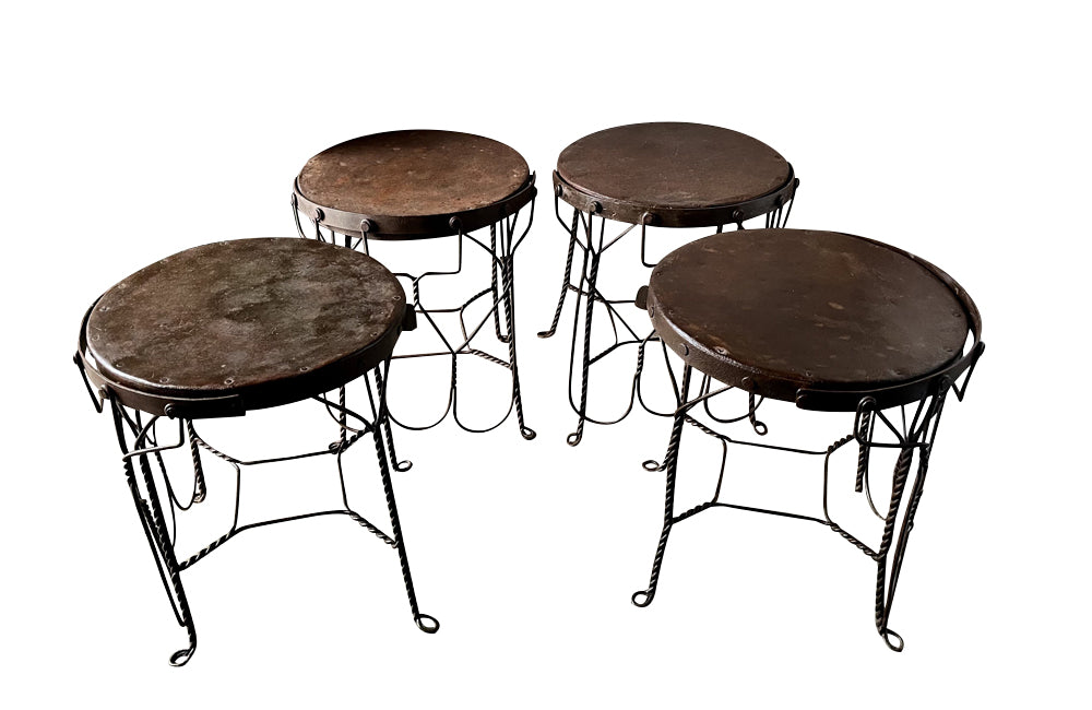 An elegant set of four mid-20th Century French wrought-iron folding chairs of the 'Bouchon de Champagne' type.