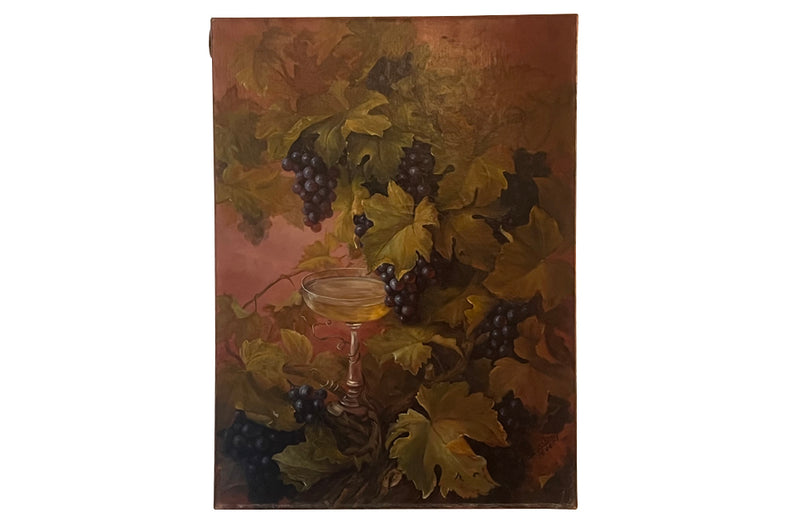 Large French still life painting of grapes and a champagne filled glass coupe.