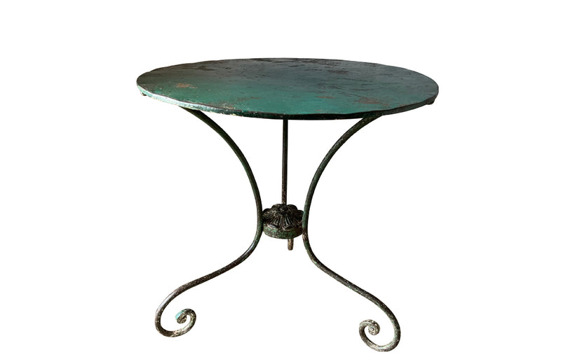 French green iron gueridon with lovely scrolled wrought iron legs and pretty cast iron central floral medallion. Remains of its original layers of paint. 