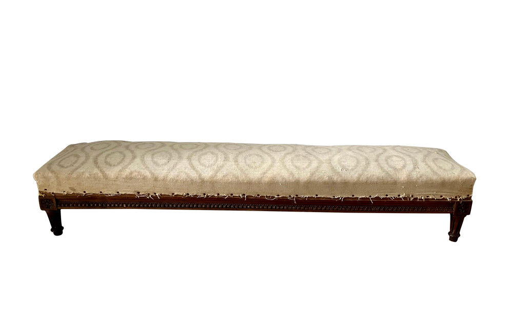 long charming 19th century foot stool has reeded legs and carving to all sides in the Neo-Classical style. 