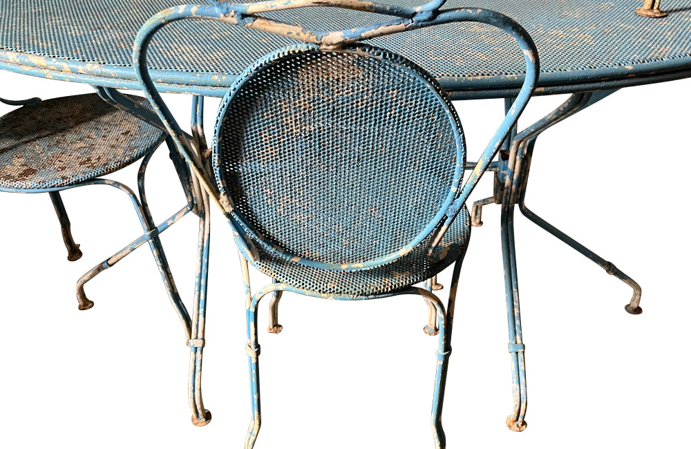 Large French mid century oval pierced iron garden table and it's matching four chairs.