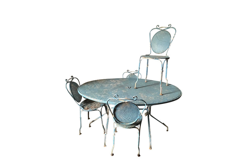 Large French mid century oval pierced iron garden table and it's matching four chairs.