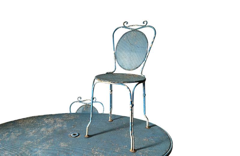 Large French mid century oval pierced iron garden table and it's matching four chairs.