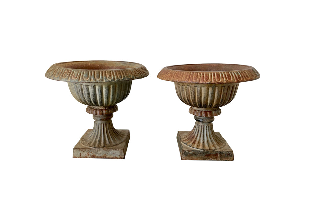 Pair of pretty French cast iron medici garden urns in the Neo-Classical style with traces of original blue paint. Circa 1930