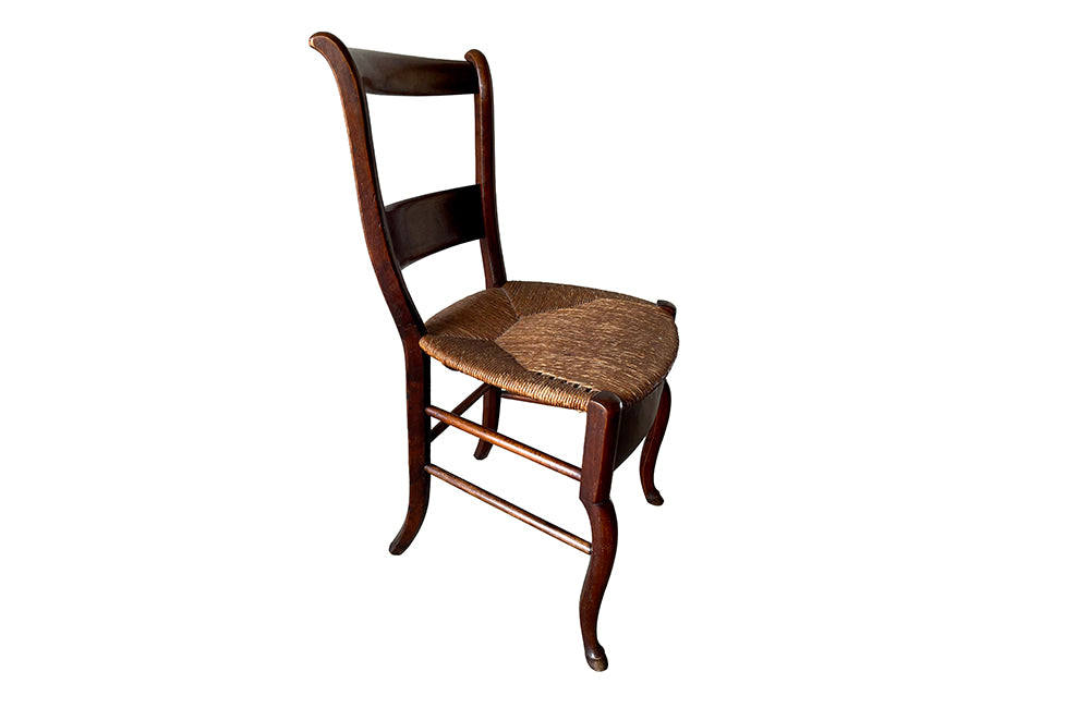Early 19th century, French walnut strawed chair and its matching footstool , both with carved hooved feet. 