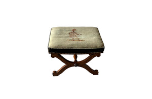 Oak x frame stool in the Neo-Classical style with spindle stretcher its charming tapestry depicting a Caribbean female figure. 19th century