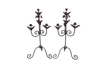 Pair of large wrought iron candle holders from a chateau in the Dordorgne.  Tall decorative candlesticks with floral and foliate decoration and have 4 candle holders.