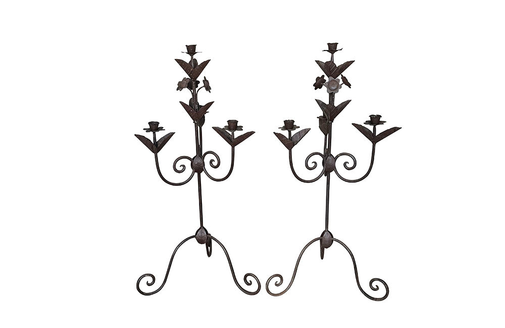 Pair of large wrought iron candle holders from a chateau in the Dordorgne.  Tall decorative candlesticks with floral and foliate decoration and have 4 candle holders.